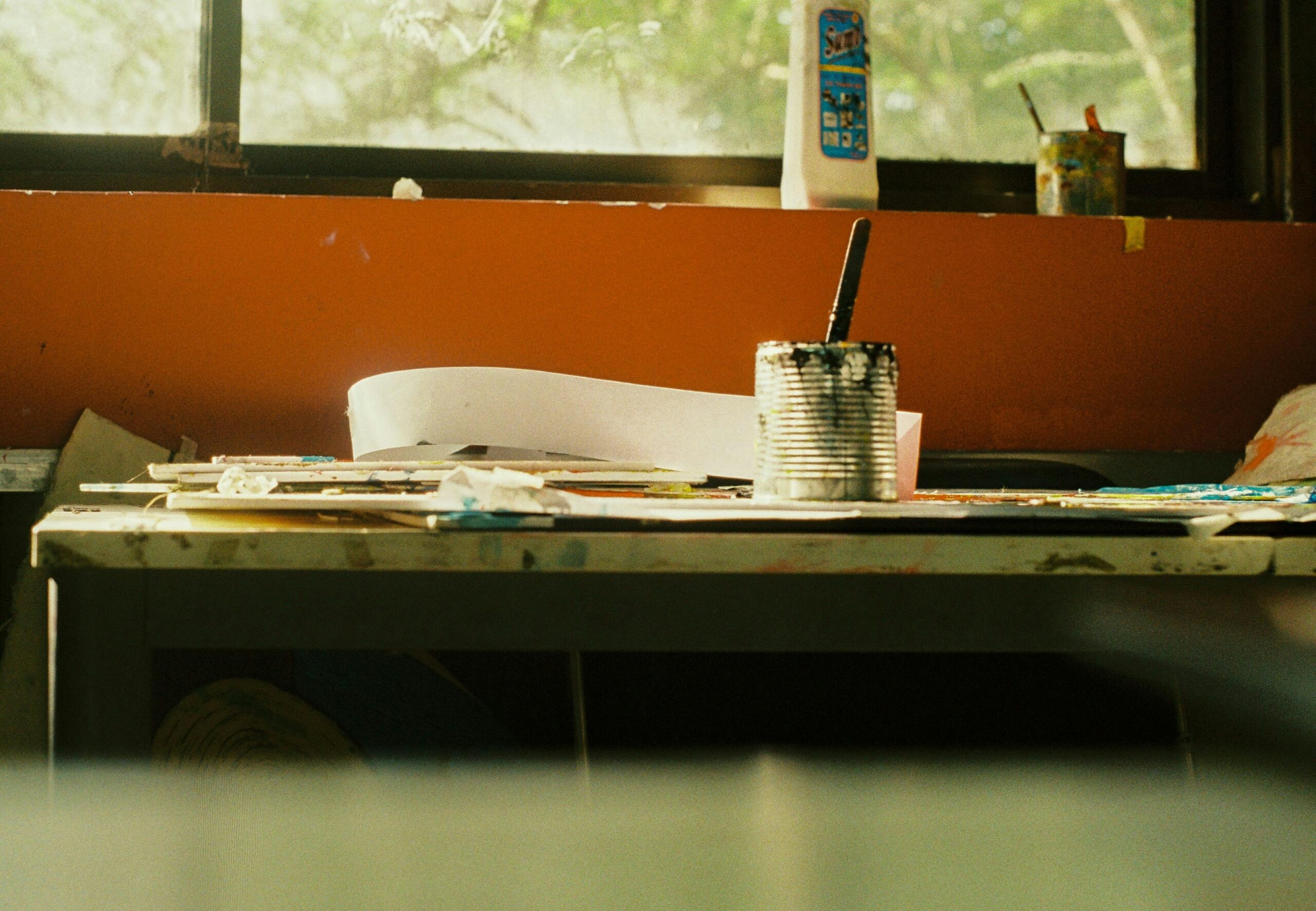 Someone sitting at a desk, deep in thought, surrounded by stacks of paperwork related to insurance policies.