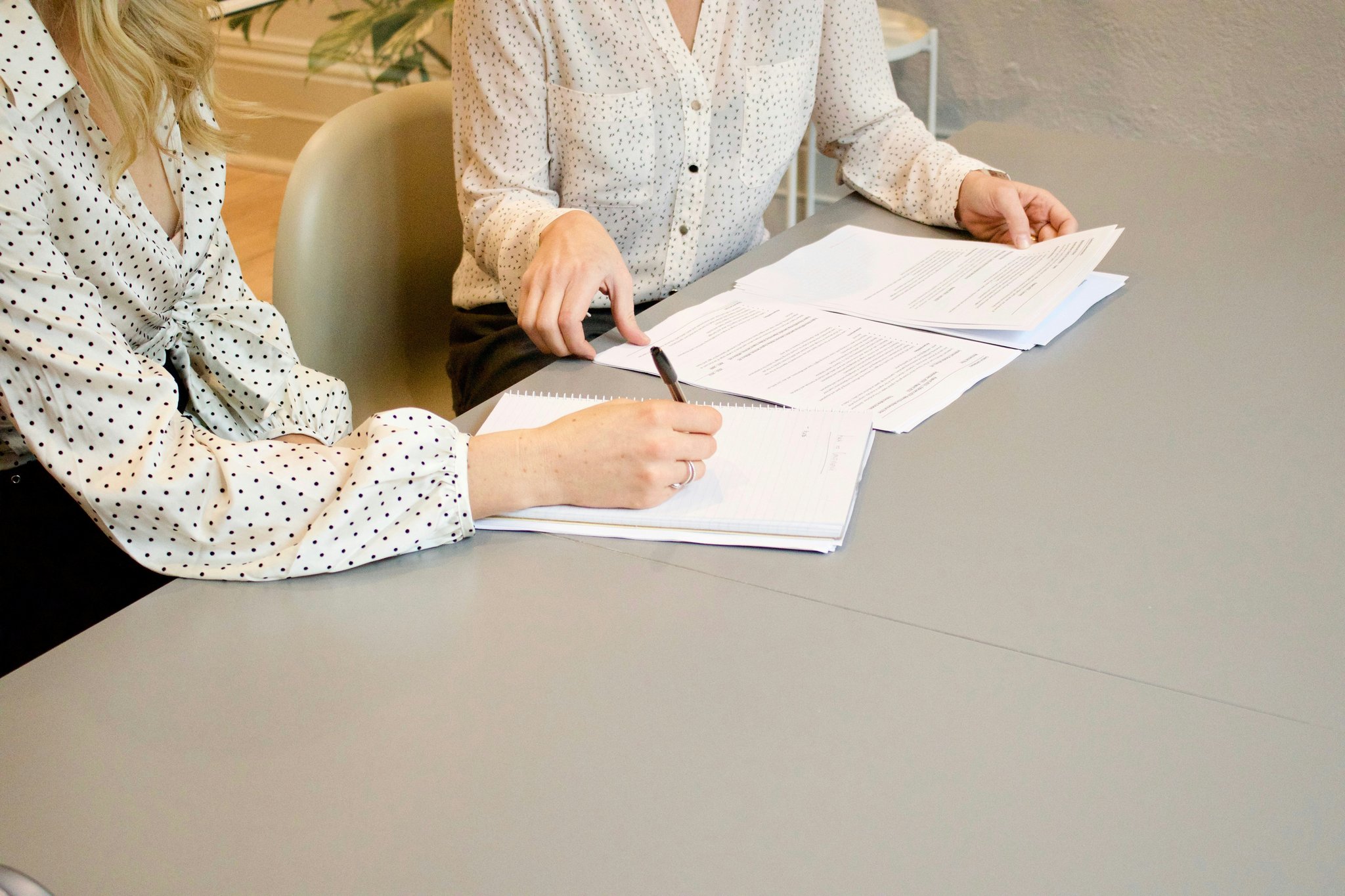 Person filling out detailed claim forms with coffee nearby.