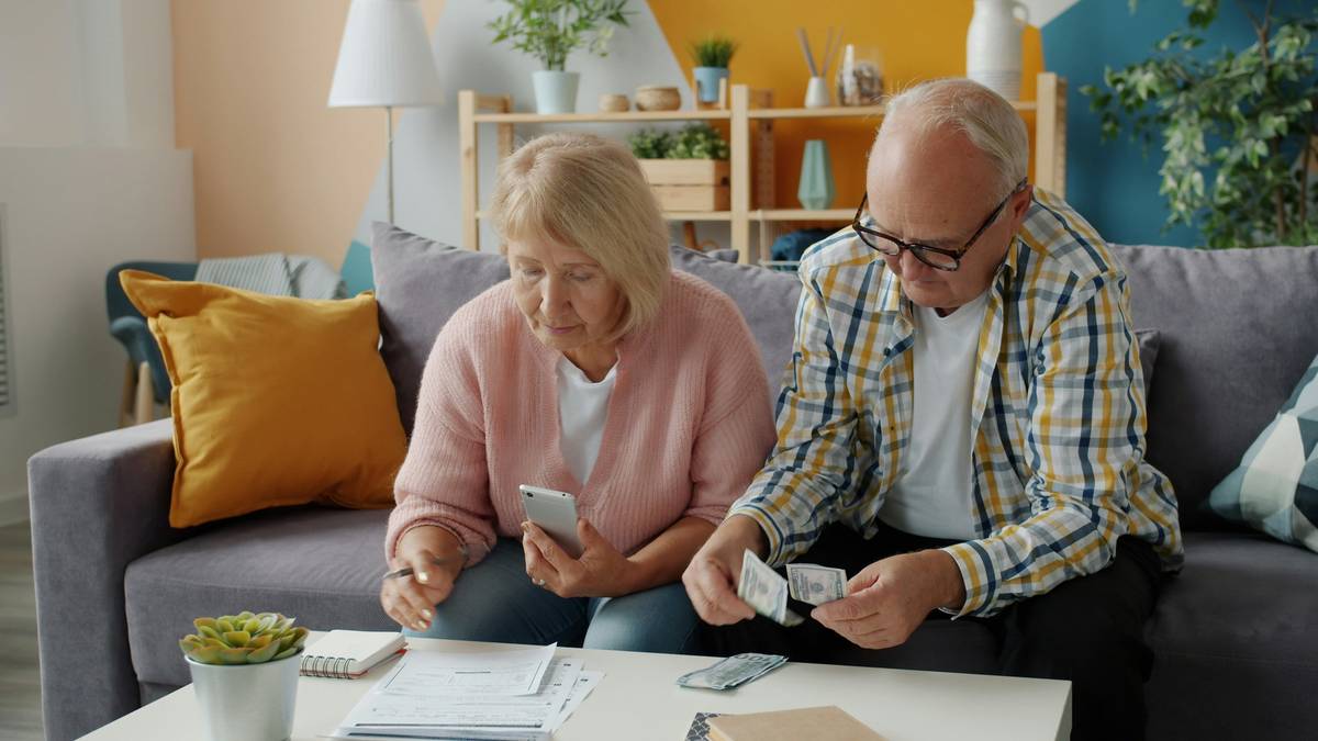 Senior couple smiling while reviewing financial documents together