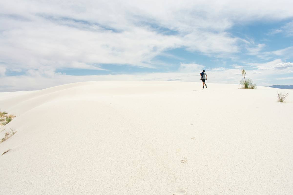 a person standing on top of a sandy hill