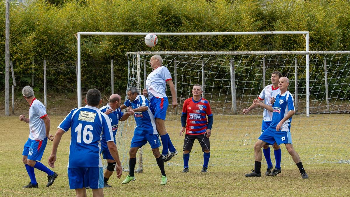 Men playing soccer, one player heading the ball.