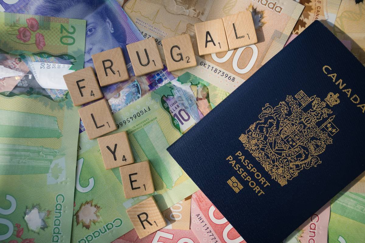 Scrabble letters spelling 'Frugal Flyer' on Canadian bills with passport